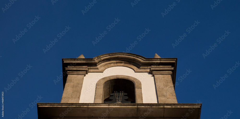 Detail of a Catholic church built in stone and the blue sky in the background.