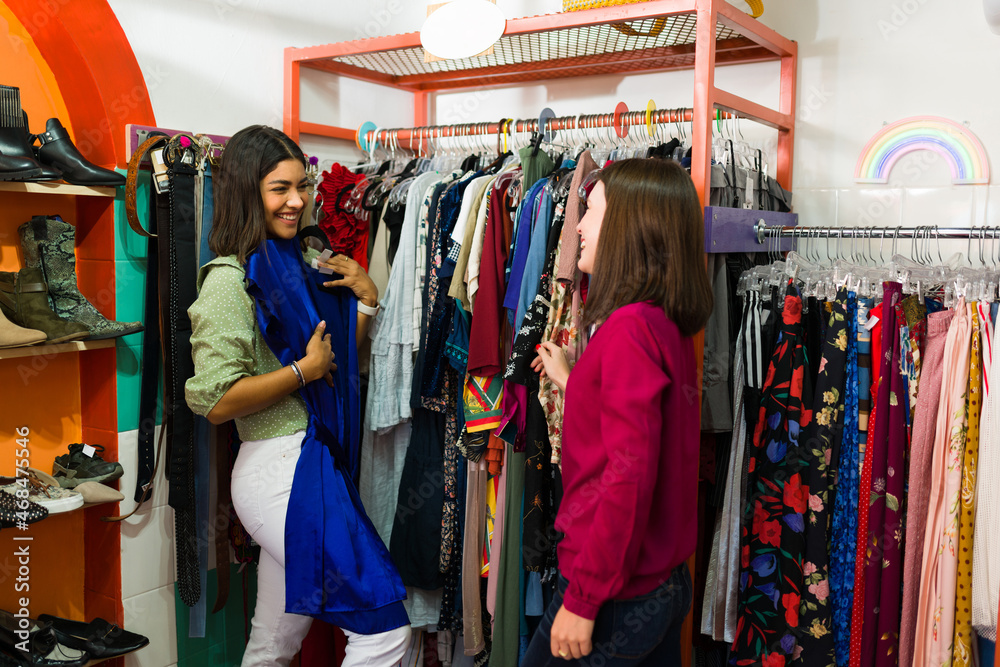 Cheerful women buying vintage dresses