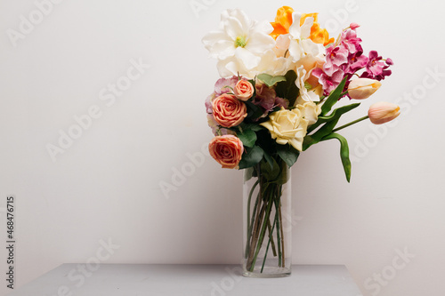 bouquet of flowers in a glass vase on a wooden table. wallpaper for a holiday card or calendar on the occasion of mother's day or international women's day. plants for the interior in the living room.