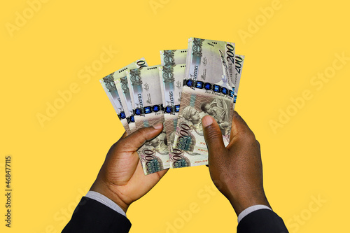 Black Hands in suit holding 3D rendered Botswanan Pula notes photo