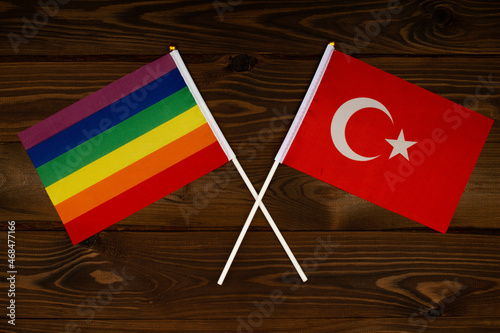 Rainbow flag LGBT and flag of Turkey on beautiful brown background with wooden texture. LGBT Pride Month. LGBTQ. LGBTQIA. Human rights concept. Close Up. Top view