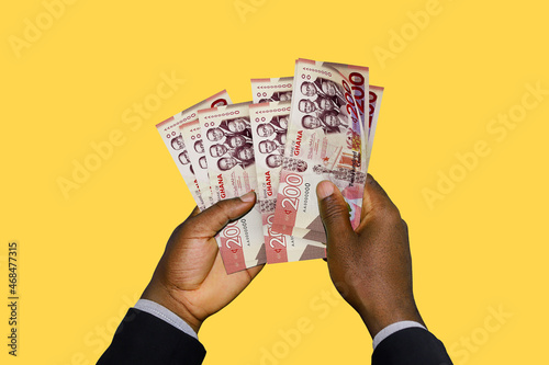 Black Hands in suit holding 3D rendered Ghanaian cedi notes photo