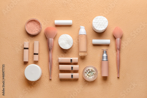 Cotton pads, decorative cosmetics and brushes on color background