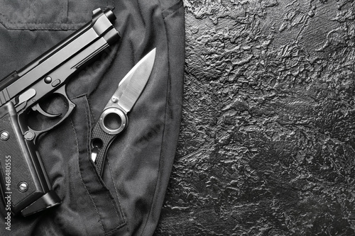 Folding pocket knife with pistol on black background