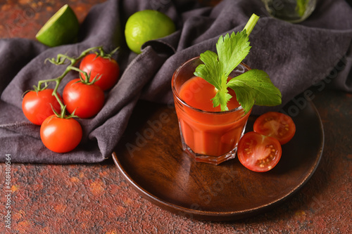 Glass of bloody mary with celery and tomatoes on grunge background