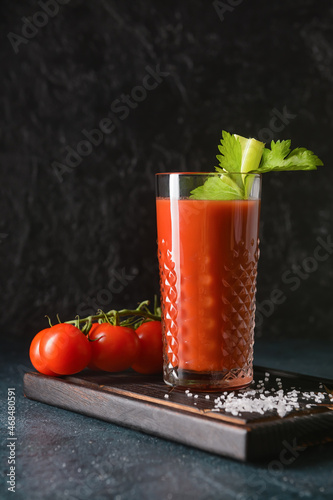 Board with glass of bloody mary on table