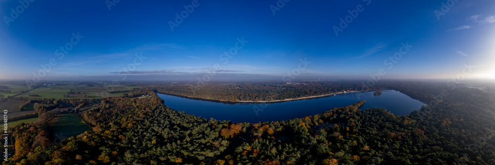 View from above horse head shaped De IJzeren Man lake surrounded by autumn forest with beaches on its shores. Aerial Dutch panorama landscape scenery.