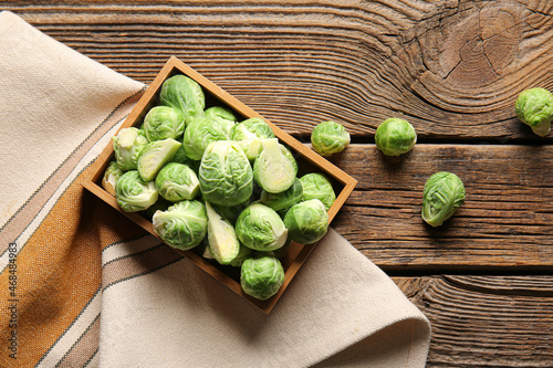 Box with fresh Brussels cabbage on wooden background