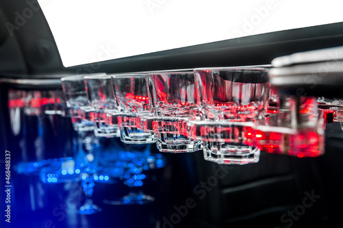 Glass glasses in neon lighting inside the luxury car limousine © Andrey