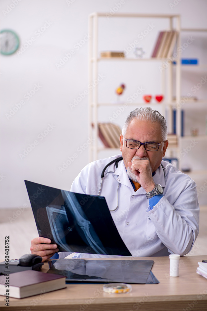 Old male doctor radiologist working in the clinic