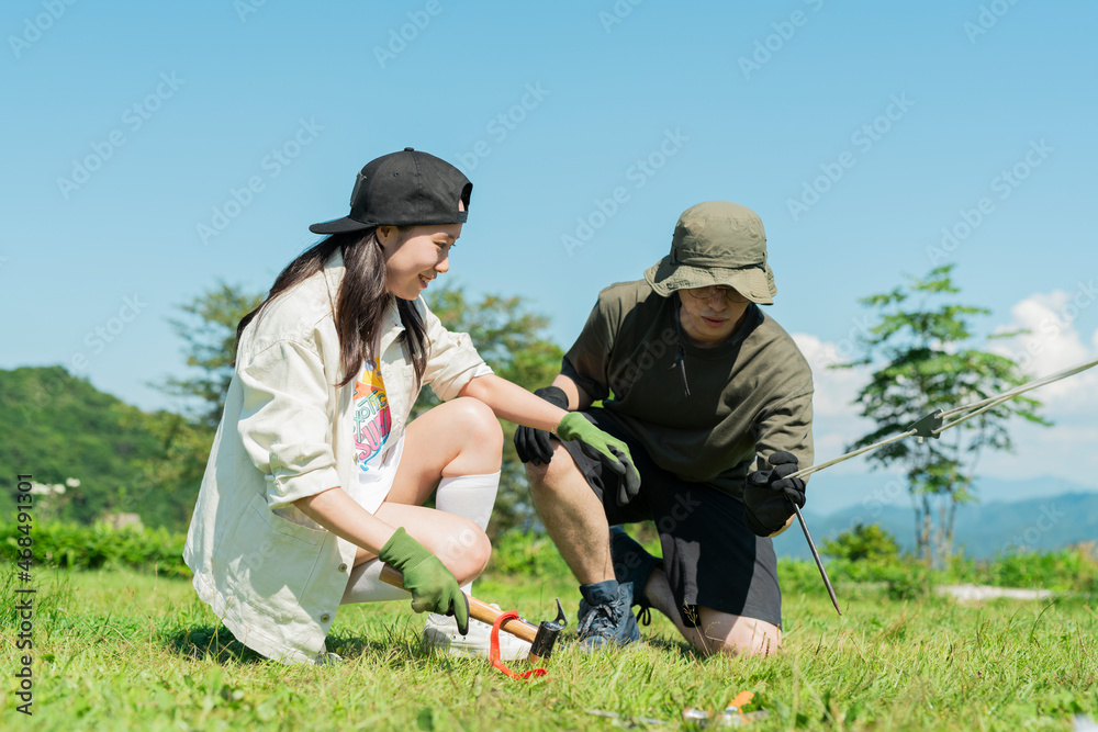 テントを張る男女 テントを張る男女