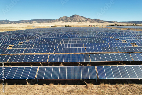 Aerial drone shot of a large solar array power plant in the desert generating clean electricity from the sun.