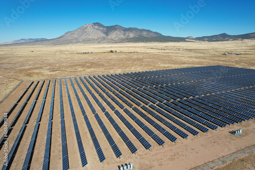 Aerial drone shot of a large solar array power plant in the desert generating clean electricity from the sun.