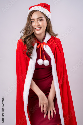 Portrait of a happy beautiful woman in red santa claus costume,Attractive young woman in red dress and hat,Christmas celebration. © visoot
