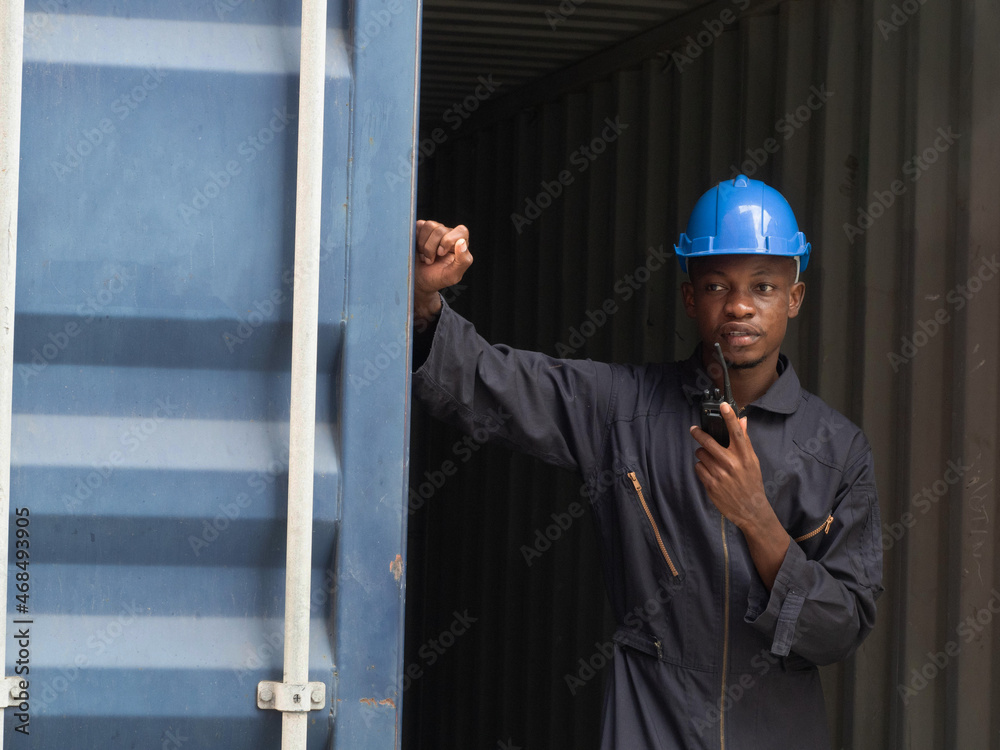 Foreman engineer manager african blue hat black shadow safety talk telephone look work report warehouse terminal container import export business company site customer logistic global international Foreman engineer manager african blue hat black shadow safety talk telephone look work report warehouse terminal container import export business company site customer logistic global international
