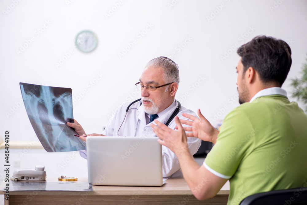 Young man visiting old male doctor radiologist Young man visiting old male doctor radiologist