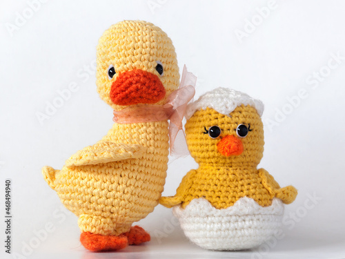 Handmade knitted stuffed animals. A young duck with a newborn yellow chick just hatched from an egg