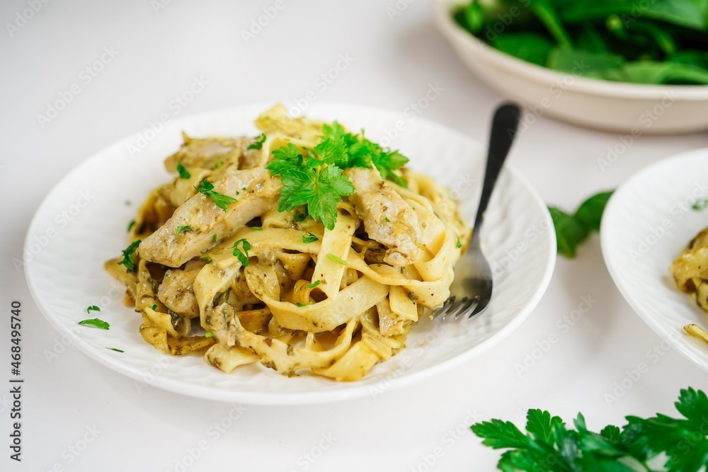 Homemade spinach chicken Alfredo pasta on white background Homemade spinach chicken Alfredo pasta on white background