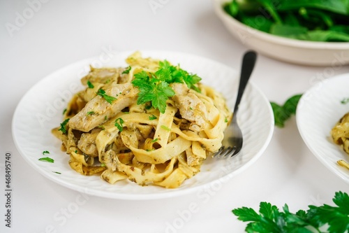 Homemade spinach chicken Alfredo pasta on white background