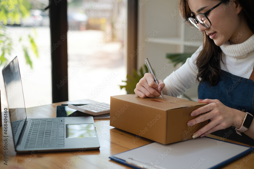 Business owner writing address before send to customer. Successful SME entrepreneur concept Business owner writing address before send to customer. Successful SME entrepreneur concept
