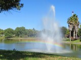 fountain with rainbow in a park
