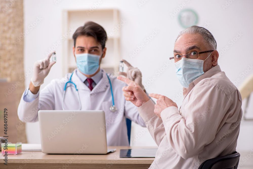Old male patient visiting young male doctor in vaccination conce