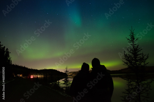 Couple enjoying the northern lights in Whitehorse, Yukon(Canada).