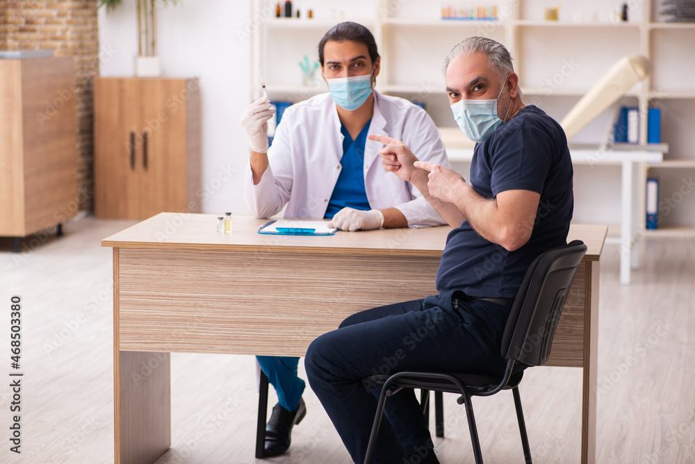 Old man visiting young doctor in covid-19 vaccination concept Old man visiting young doctor in covid-19 vaccination concept