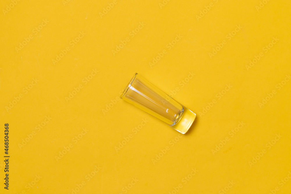 top view of shot glass for tequila, on yellow background top view of shot glass for tequila, on yellow background