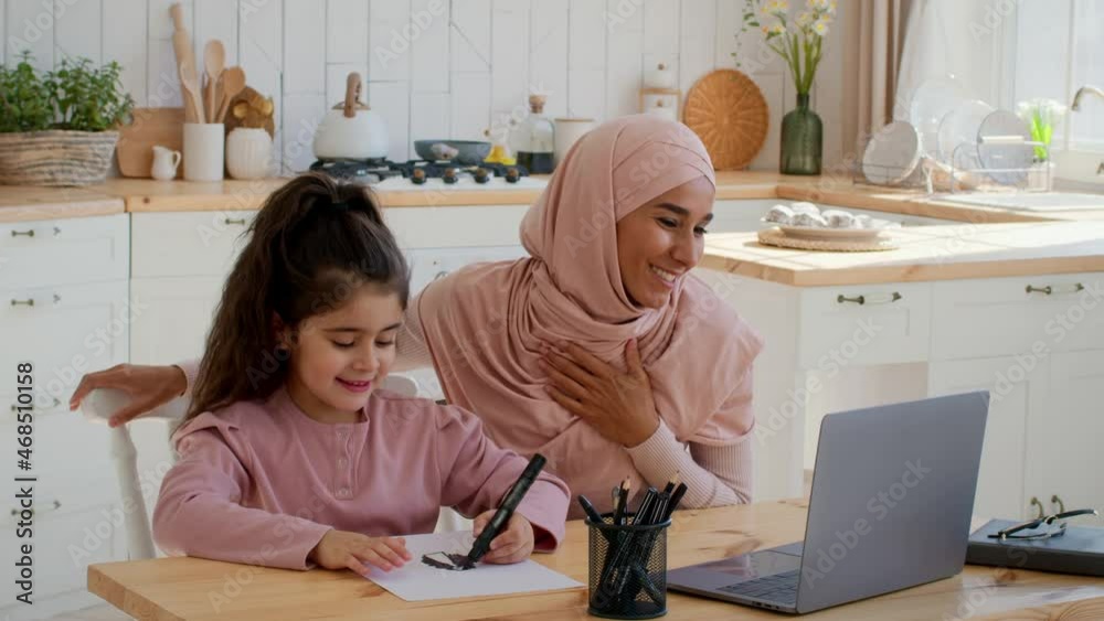 Islamic Mom And Little Daughter Video Calling Using Laptop Indoors Islamic Mom And Little Daughter Video Calling Using Laptop Indoors