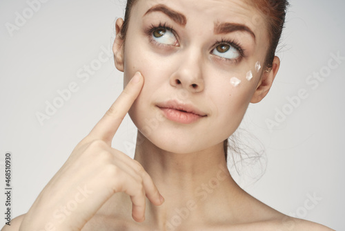 woman with bare shoulders face cream skin care close-up