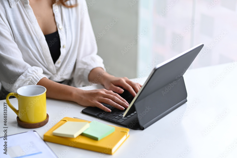 Cropped shot businesswoman using computer tablet on office desk. Cropped shot businesswoman using computer tablet on office desk.