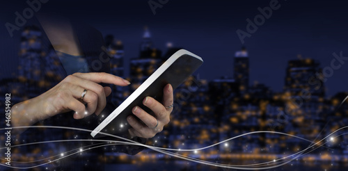 Innovative, and global network connection, Data exchanges. Hand touch white tablet with digital hologram wave sign on city dark blurred background. Business network communication and innovation.
