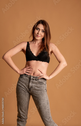 Beautiful woman in beige swimsuit on pink background © kalinichenkod