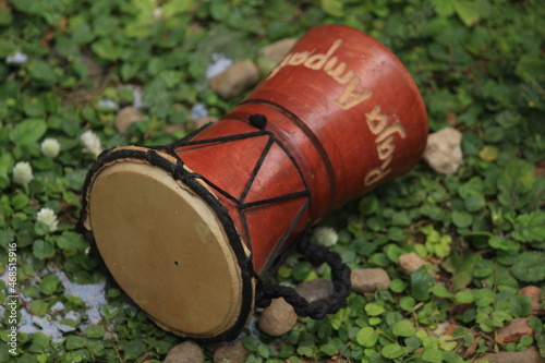 unique souvenirs of traditional percussion instruments called Kendang typical of Papua Indonesia, made of wood and animal skins with distinctive ethnic carvings. photo