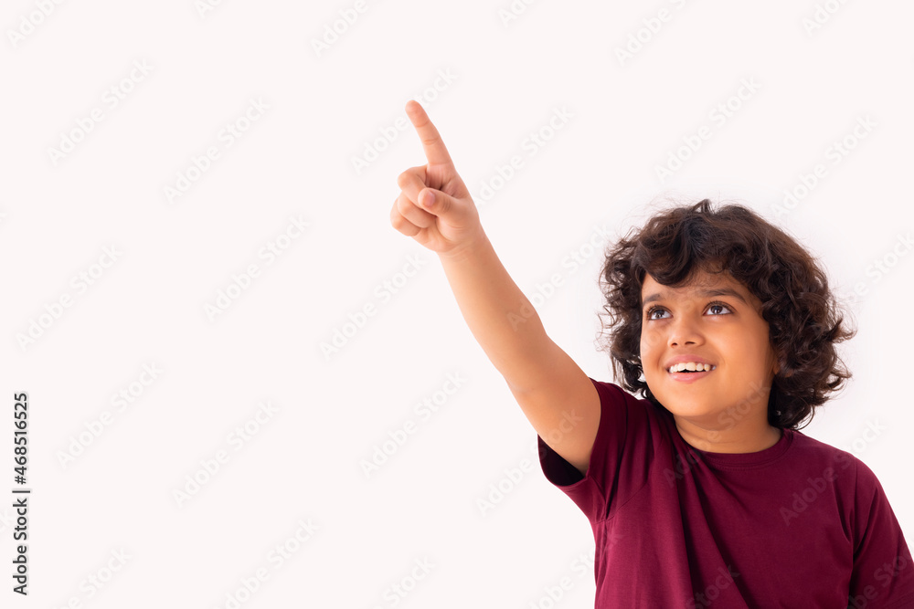 A BOY HAPPILY POINTING WHILE LOOKING ABOVE A BOY HAPPILY POINTING WHILE LOOKING ABOVE