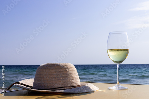 Romantic glass of white wine, on the sea beach. Wine tasting and relaxation at the resort