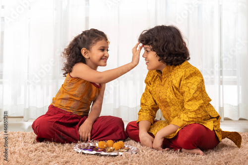 Little Girl applying tika on forehead of her brother on the occasion of Bhai Dooj photo