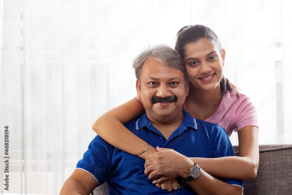 Indian father and girl spending good time while sitting on sofa Indian father and girl spending good time while sitting on sofa