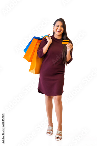 Indian young girl with shopping bags holding credit cards in her hand