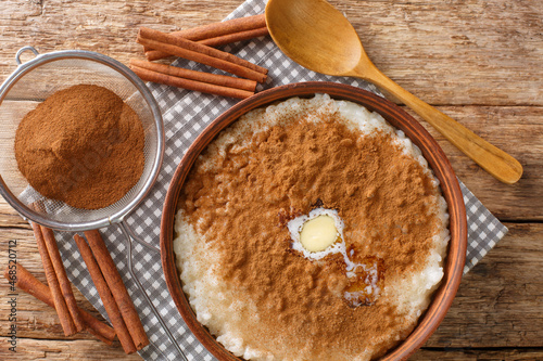 Cinnamon rice pudding risengrod close up in the bowl on the table. Horizontal top view from above photo