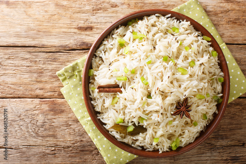 Vegetarian Indian Jeera rice with cumin and other spices close up in the bowl on the table. Horizontal top view from above