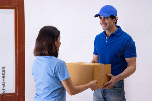 Indian woman accepting parcel from delivery boy at home © IndiaPix