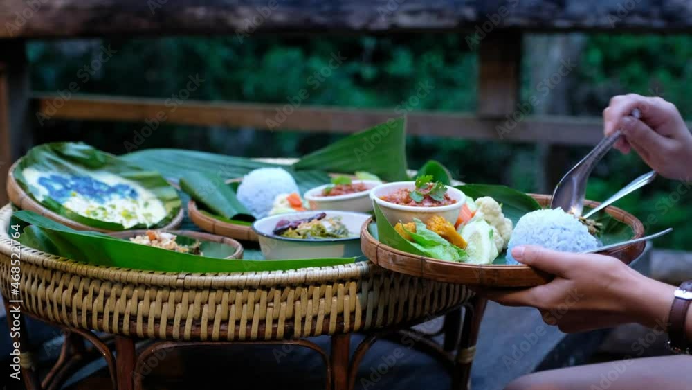 A woman eating Northern Thai food for dinner on wooden house balcony A woman eating Northern Thai food for dinner on wooden house balcony