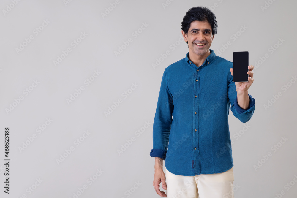 Indian man showing his smartphone in front of camera Indian man showing his smartphone in front of camera