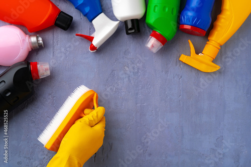 Cleaning supplies with hands in rubber gloves on gray background © fotofabrika