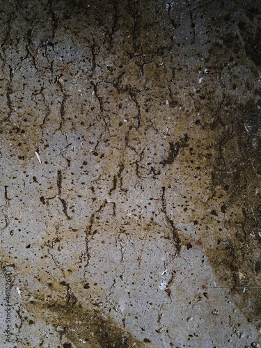 Textured concrete background with many potholes, scratches, irregularities, scuffs with colored traces. Vertical