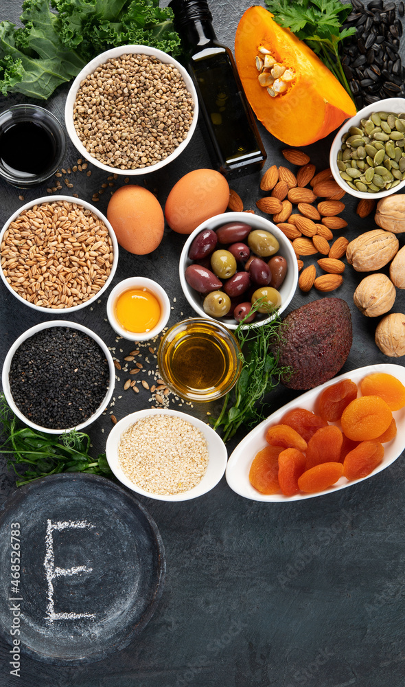Foods high in vitamin E on dark background.