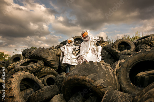 Ein Paar steht im Hitzeschutzanzug auf Autoreifen