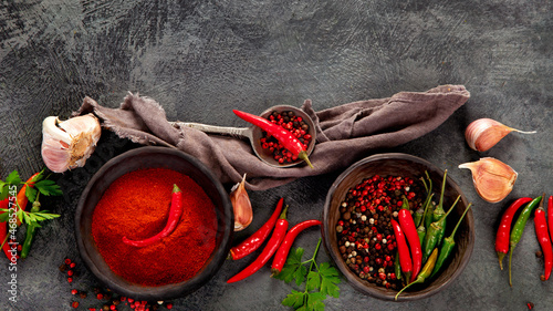 Fotografia Red chili or chilli cayenne pepper and peppercorns on dark background